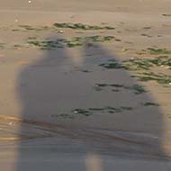 We see two elongated shadows of a couple on the beach, Broadstairs, Kent