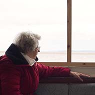 Elderly Lady overlooking the River Exe from a boat window.