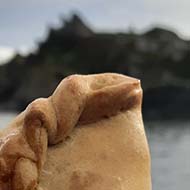A Cornish pasty against with the sea in the background