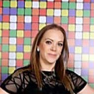 Three people standing in a room filled with rubik's cubes