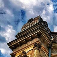 Historic building with modern front under blue sky with clouds