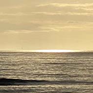 A rocky beach with the tides lit by a low sun