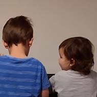 Two children sitting in front of a piano