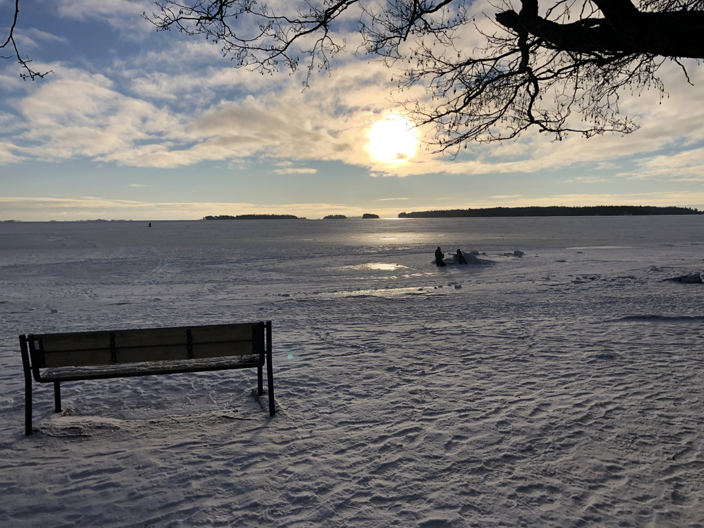 Snowy landscape with the sun low in the horizon.