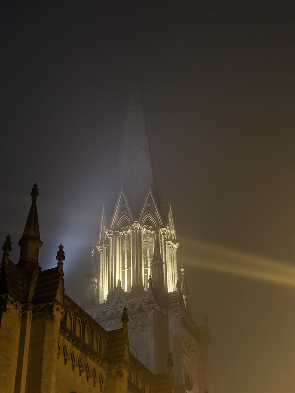Church tower glowing with light in the fog