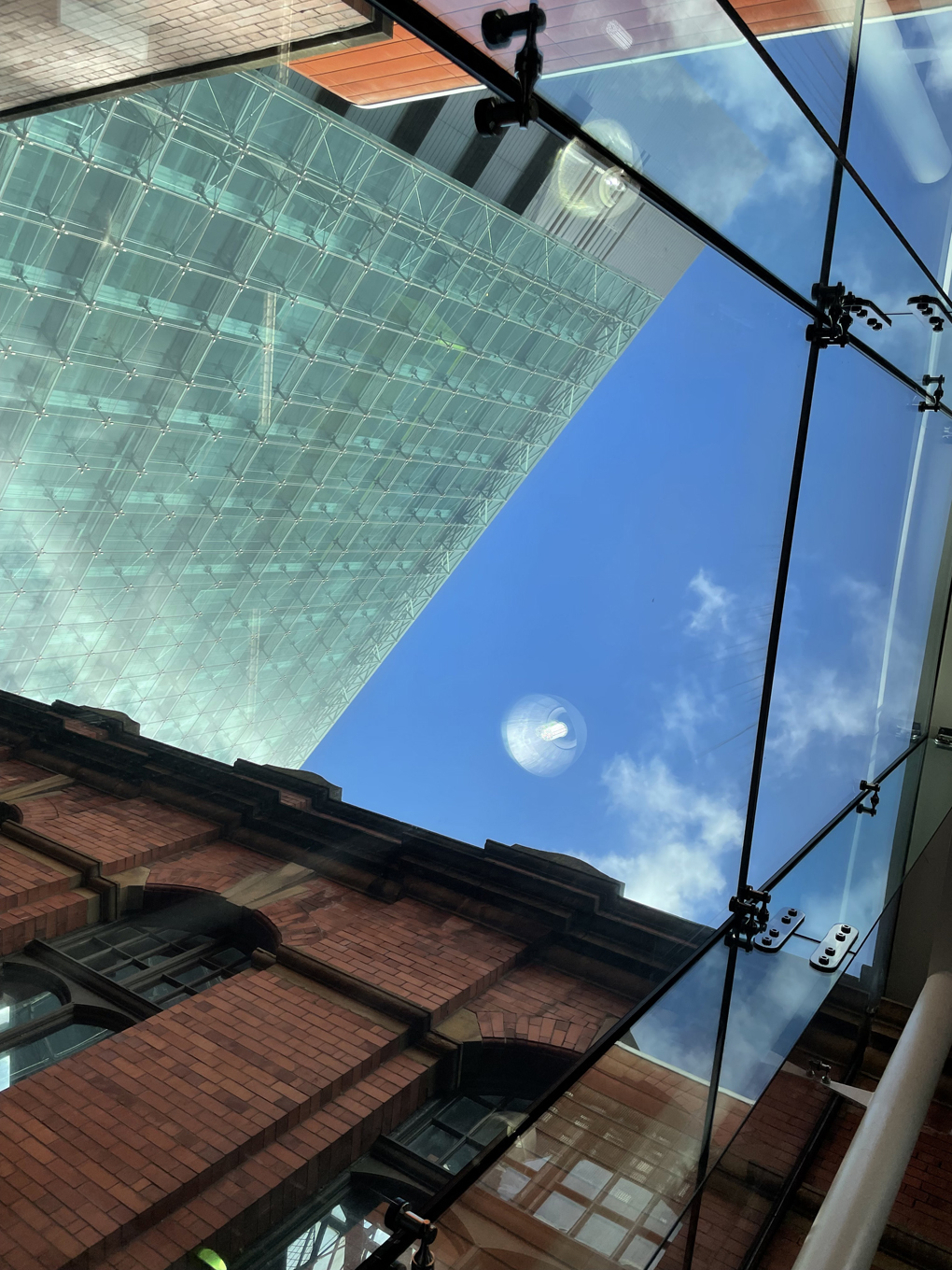 Picture of the sky through the window of a brick and glass building