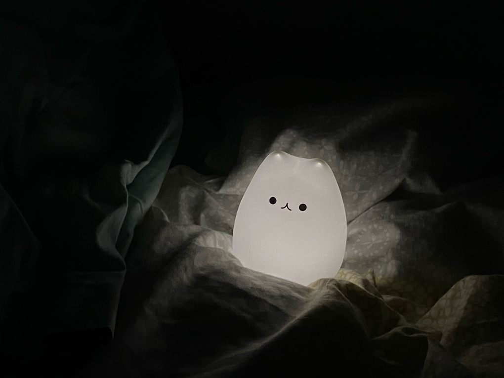 A small glowing light shaped like a rotund cartoon cat