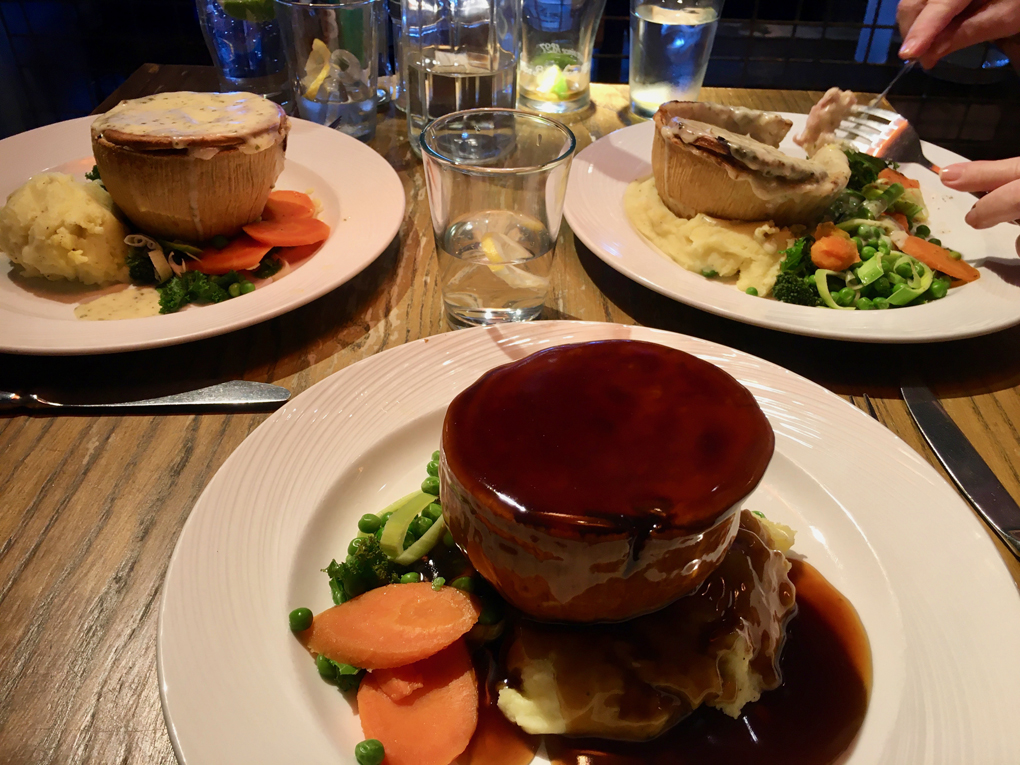 A pub table showing three meals which are about to be consumed.