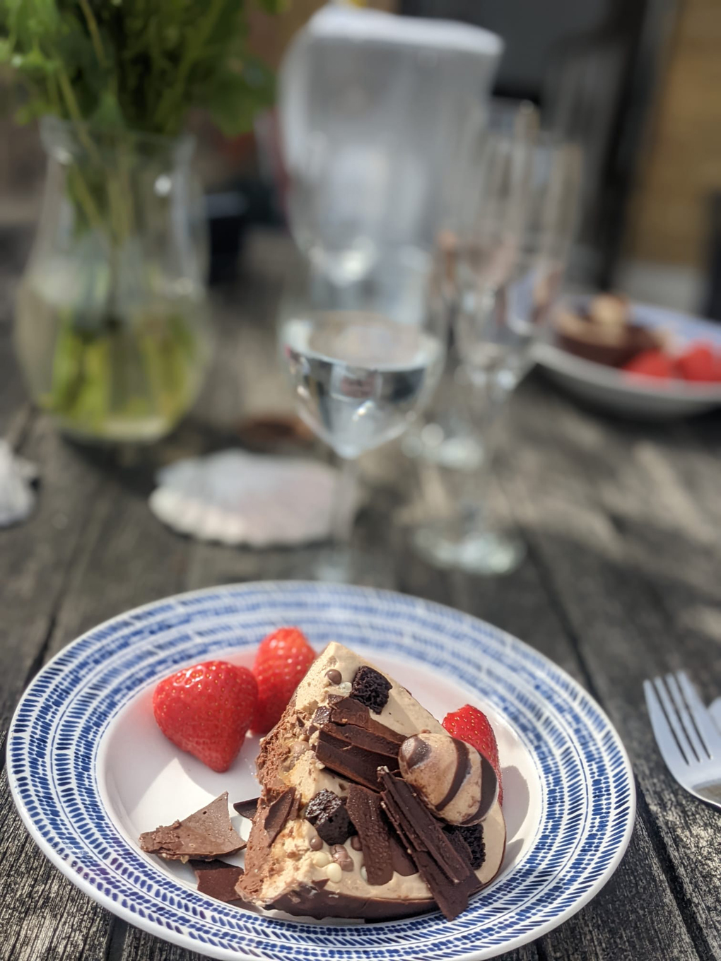 Half an Easter egg dessert, blurred background, glasses table in the sun