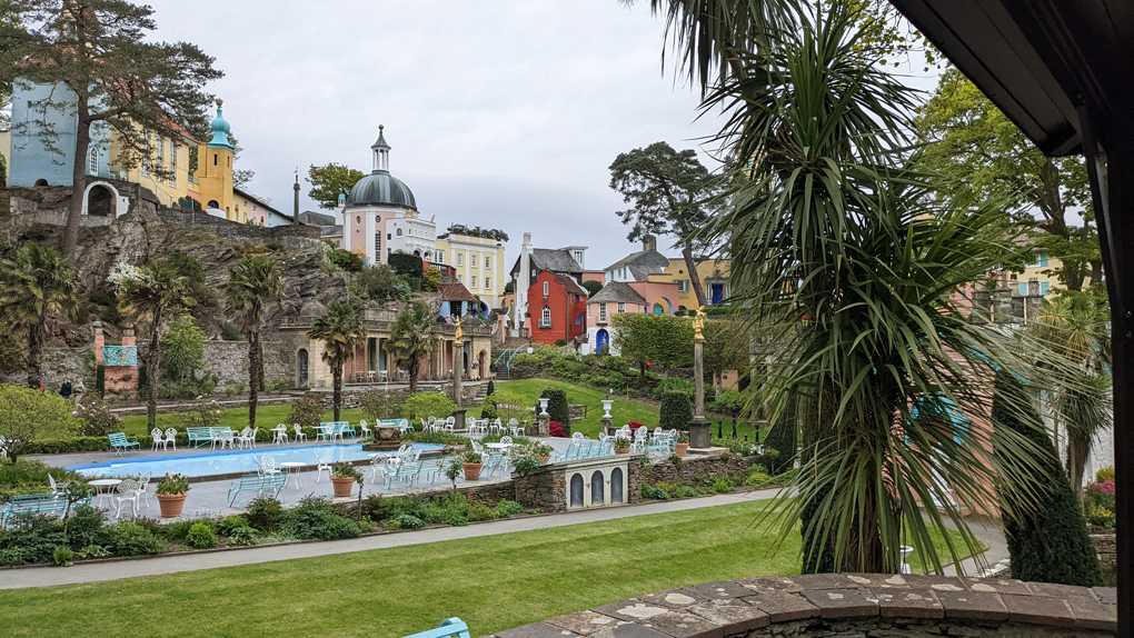 The village square of Portmeirion, featuring pillars, turrets, fountains and brightly coloured buildings.