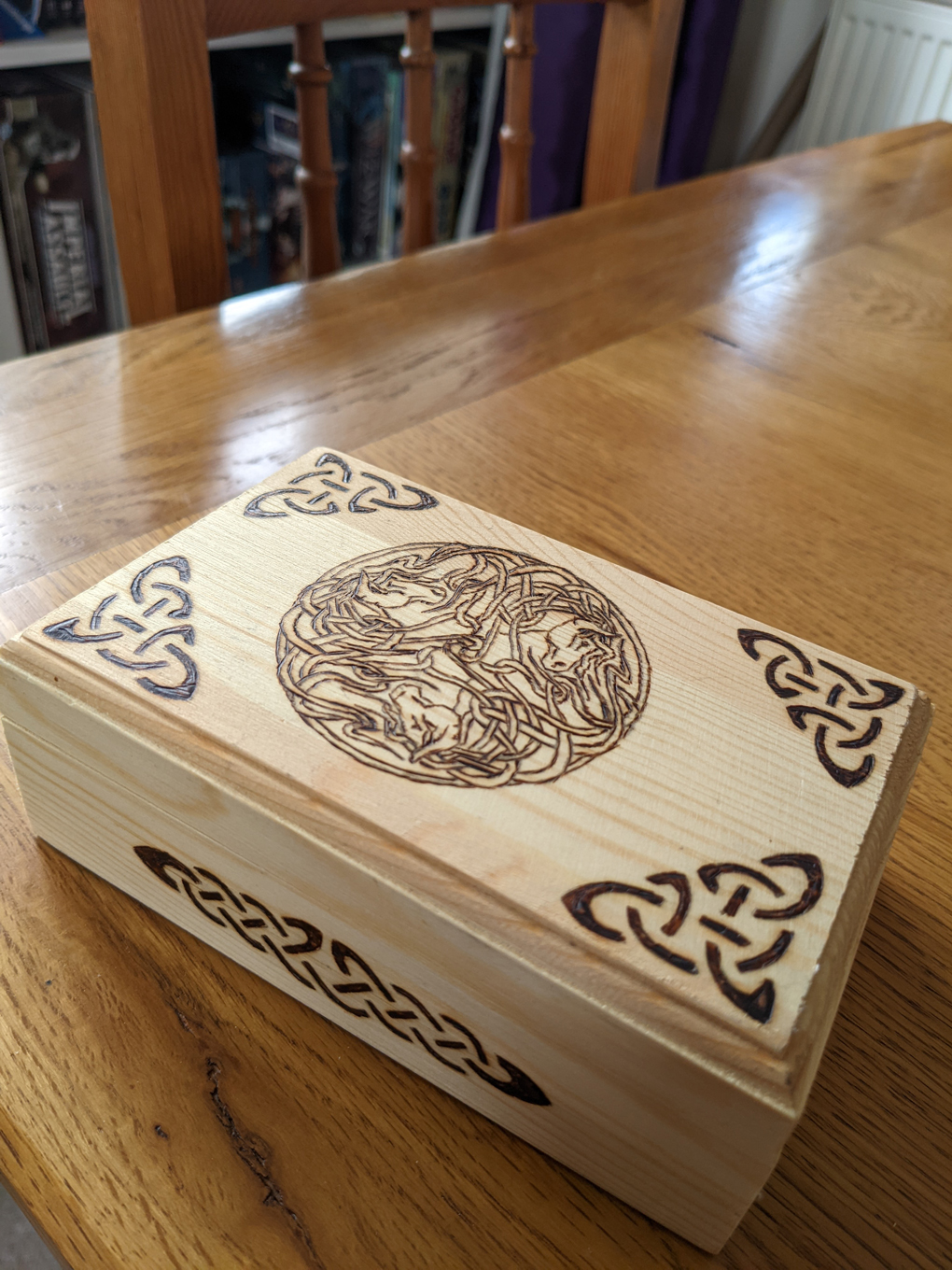 A wooden box with pyromantic detail, Celtic knots and a central design of interwoven horses