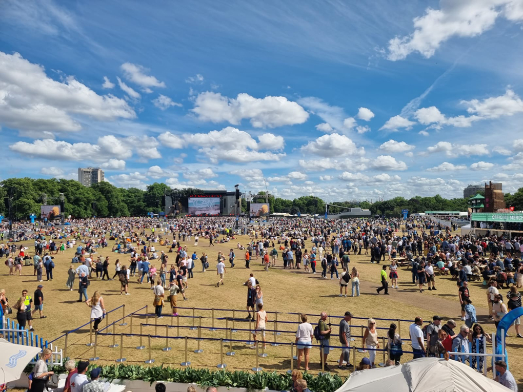 Band playing on stage at an open air festival with large crowd