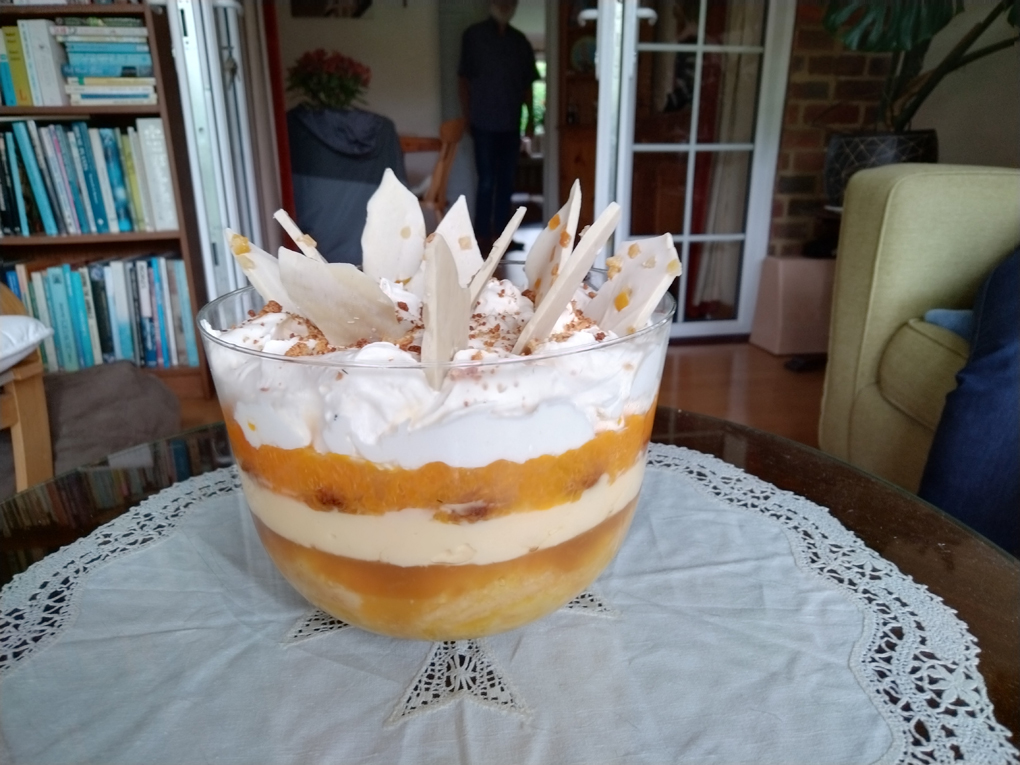 It's a trifle with layers of Swiss roll, jelly, custard, amaretto biscuits, mandarin couly and cream and topped with white chocolate shards in a big glass bowl