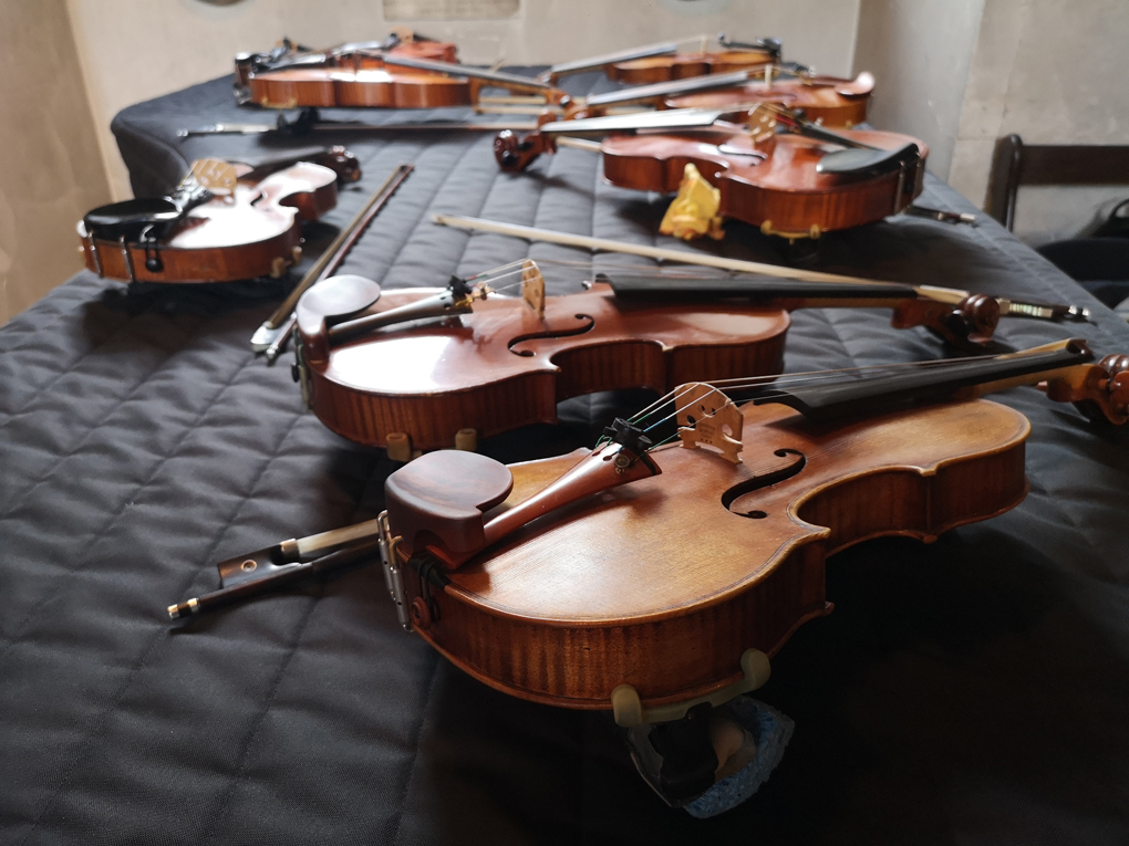 violins sitting on top of a grand piano