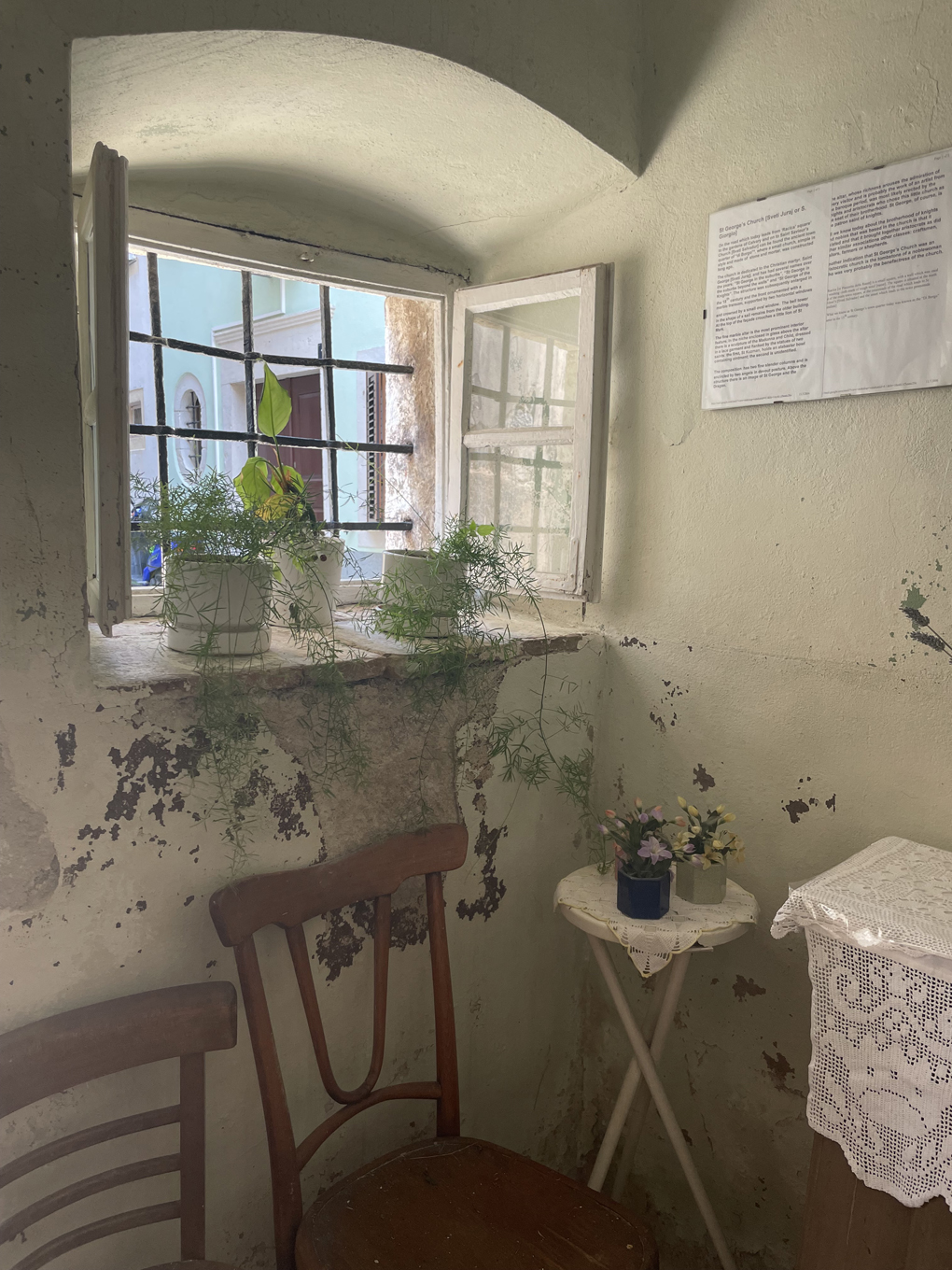 Image of the inside of a church looking through the window to the outside.