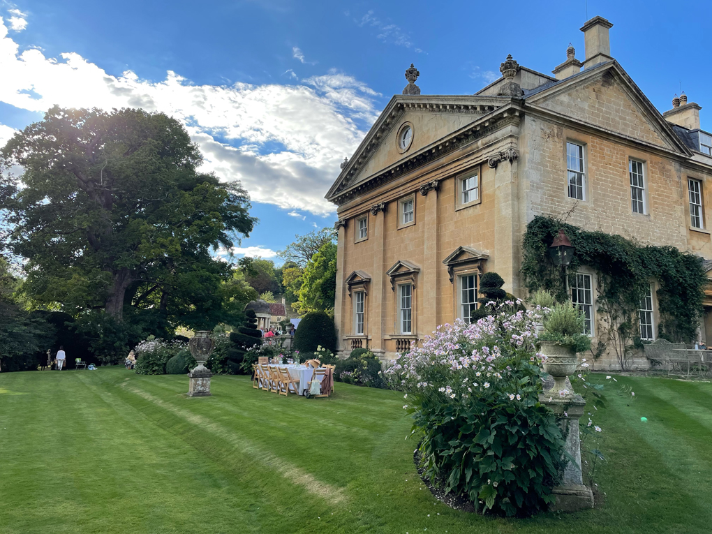 Beautiful Manor House with a perfect lawn in front. Blue sky with clouds