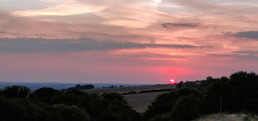 Sunset at Brill on the Hill, lots of bright reds and oranges in the sky.