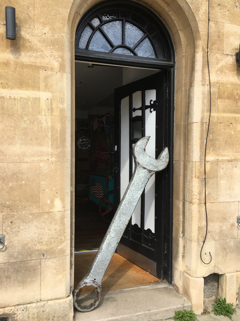 A giant wrench being used as a combined barrier and doorstop