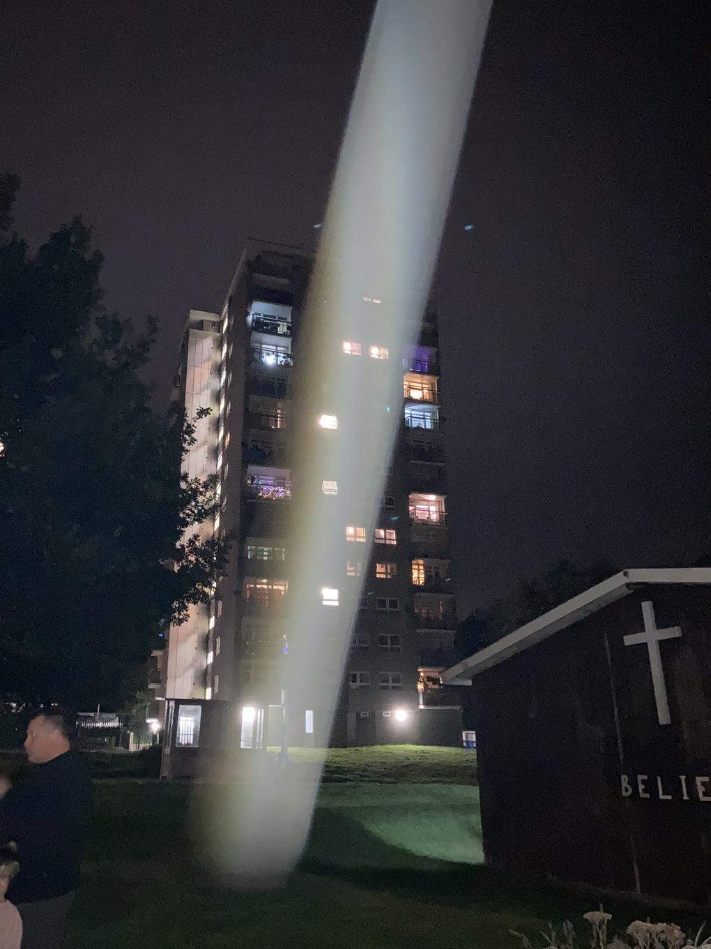 We see a shaft of light over a block on a housing estate