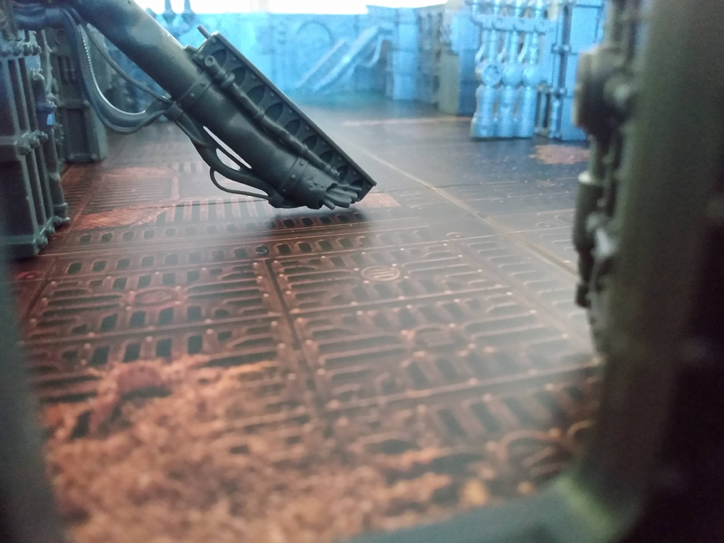 A grey, plastic spaceship walls and pipes sit on a coloured board.
