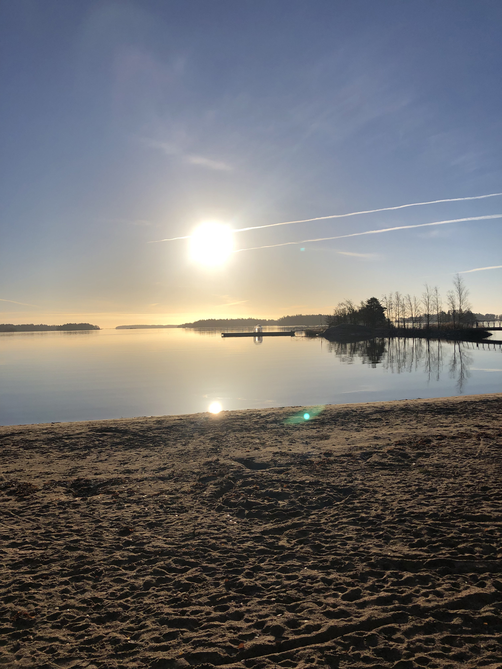 Low sun over a tranquil beach.