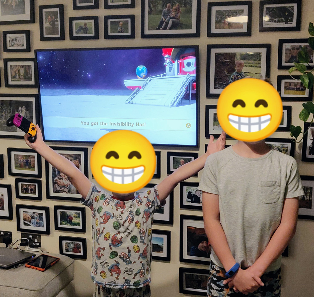 Picture of my two sons infront of the TV after completing Mario Odyssey