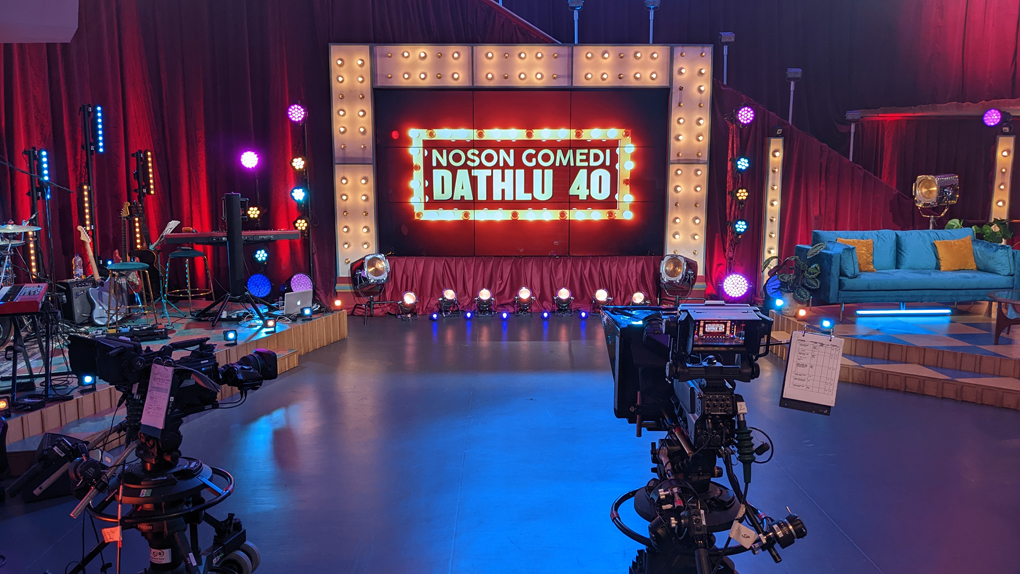 An empty stage with TV cameras, sofa and space for a live band.