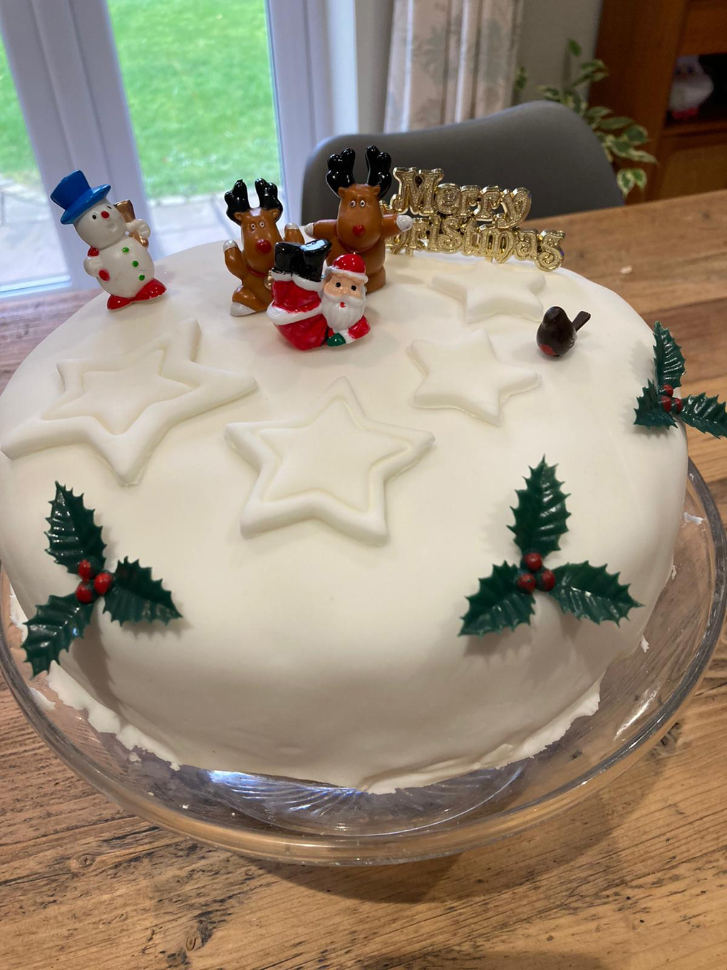 A model of Santa lounging happily on top of a Christmas cake
