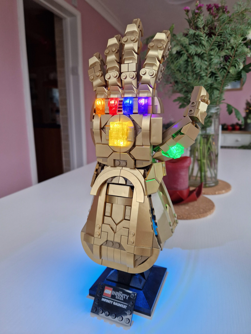 LEGO kit 76191, a golden metallic glove - the Infinity Gauntlet from the film 'Avengers: Endgame' - with an aftermarket LED illumination kit fitted, highlighting the 5 coloured 