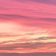 Sunset of pink and orange and clouds over buildings