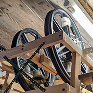 Picture of very small bells hung in a workshop.