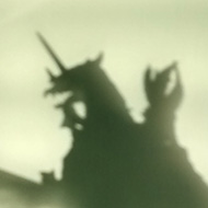 A shadow on a green wall of a wargaming miniature on horse, rearing up