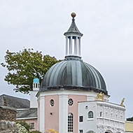 The village square of Portmeirion, featuring pillars, turrets, fountains and brightly coloured buildings.