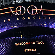 O2 arena with sign advertising a concert for the band Tool, grey skies in the background