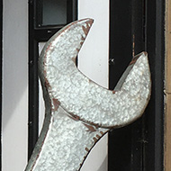 A giant wrench being used as a combined barrier and doorstop