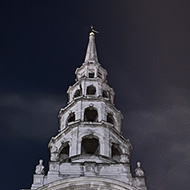 A church spire partially obscured by trees