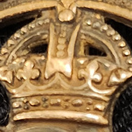 An old round badge. Composed of an outer ring with the words  For King and empire Services rendered emblased around it. The centre is cut out and has the Royal cypher of King George V