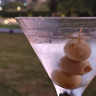 A martini sitting on the arm of a chair with a pyramid in the background