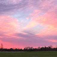 Photo of the sky with red clouds at sunset, you can just see the blue sky peaking through the wispy clouds!