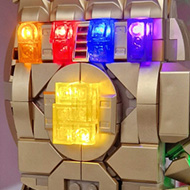 LEGO kit 76191, a golden metallic glove - the Infinity Gauntlet from the film 'Avengers: Endgame' - with an aftermarket LED illumination kit fitted, highlighting the 5 coloured 