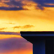 Sunset over buildings with birds silhouetted