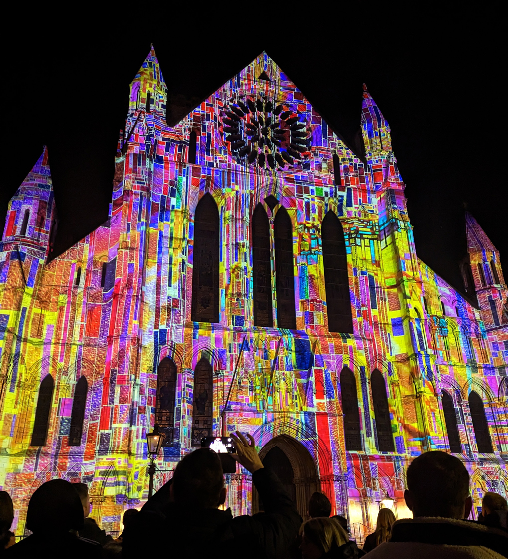 Colourful animated light projection on the front of York Minster at night