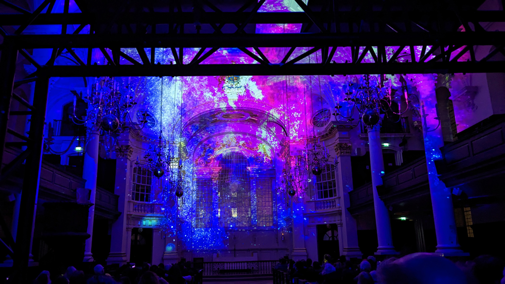 The interior of a church filled with purple and blue lights.