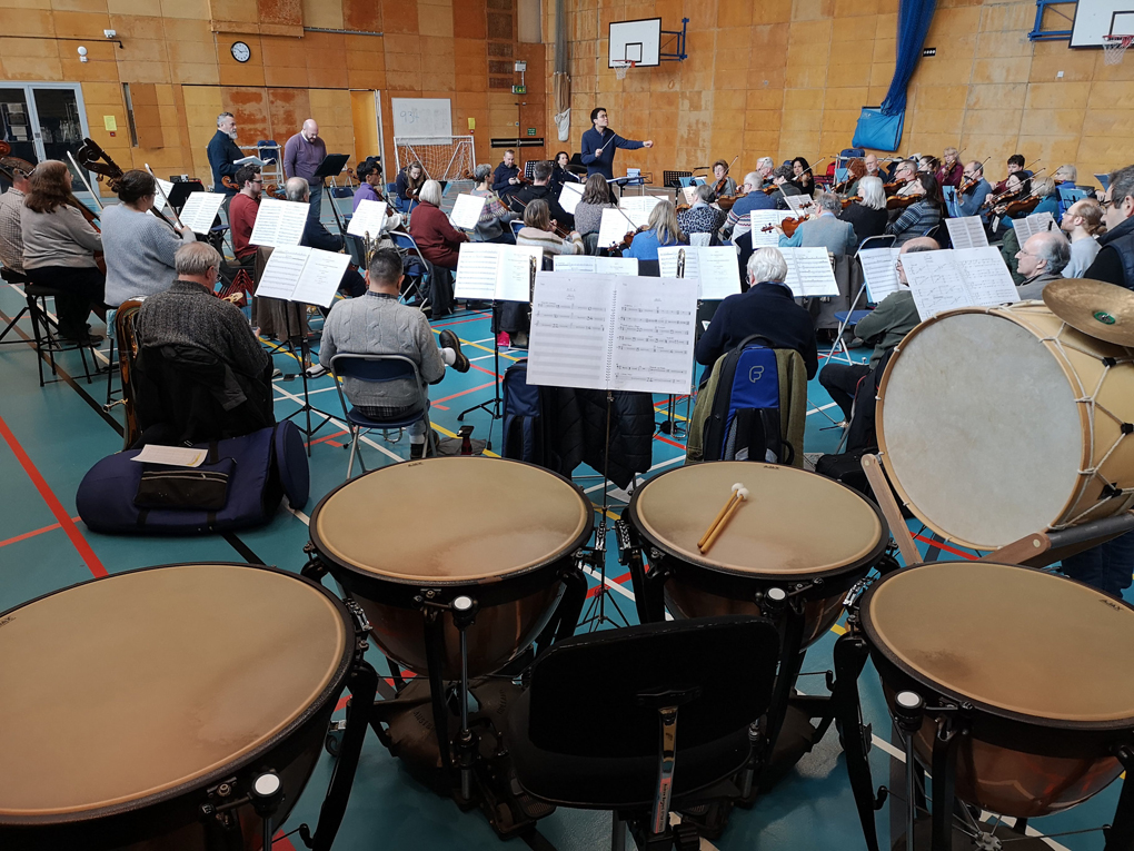 Four timpani and a bass drum with the orchestra in the background.