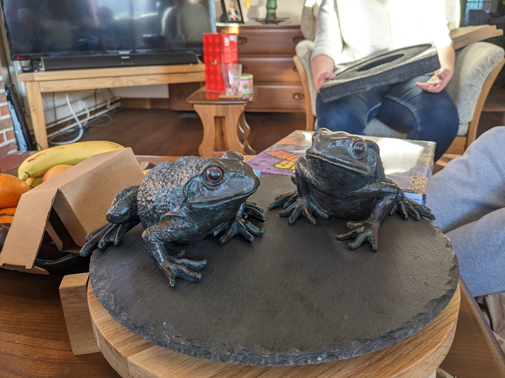 Two frog ornaments on a spinning cake stand.