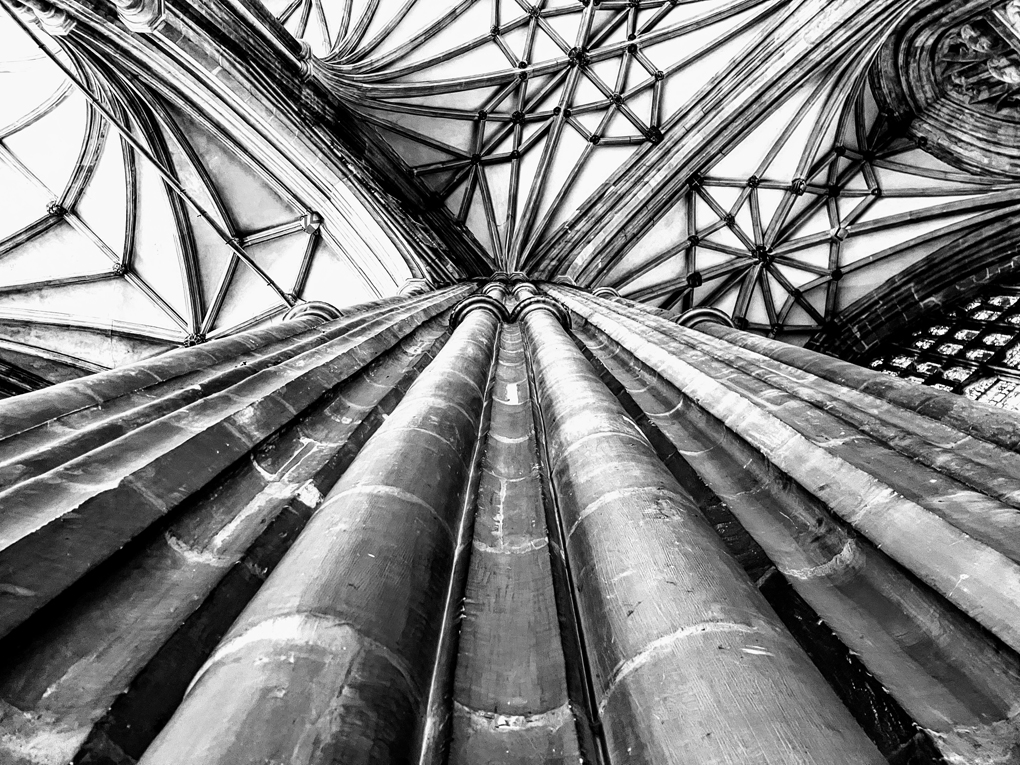 Black and white photo of one of the cathedral pillars that support the stunningly intricate stone roof of the cathedral.