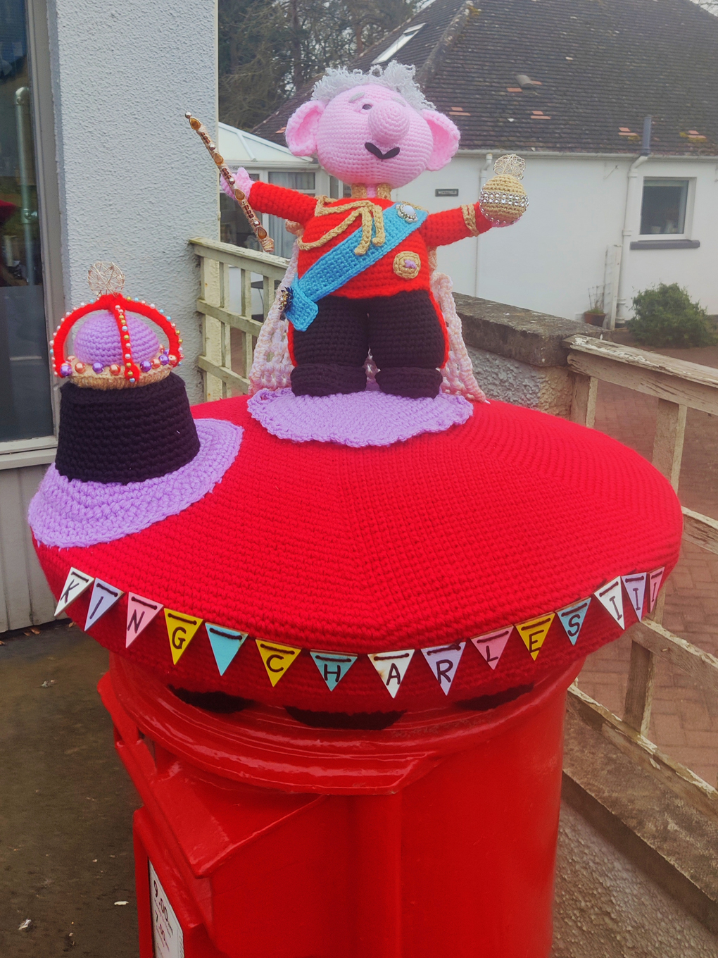 A knitted King Charles atop a post box