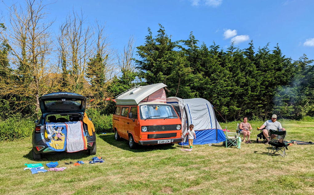 Campsite with campervan and kids wandering around