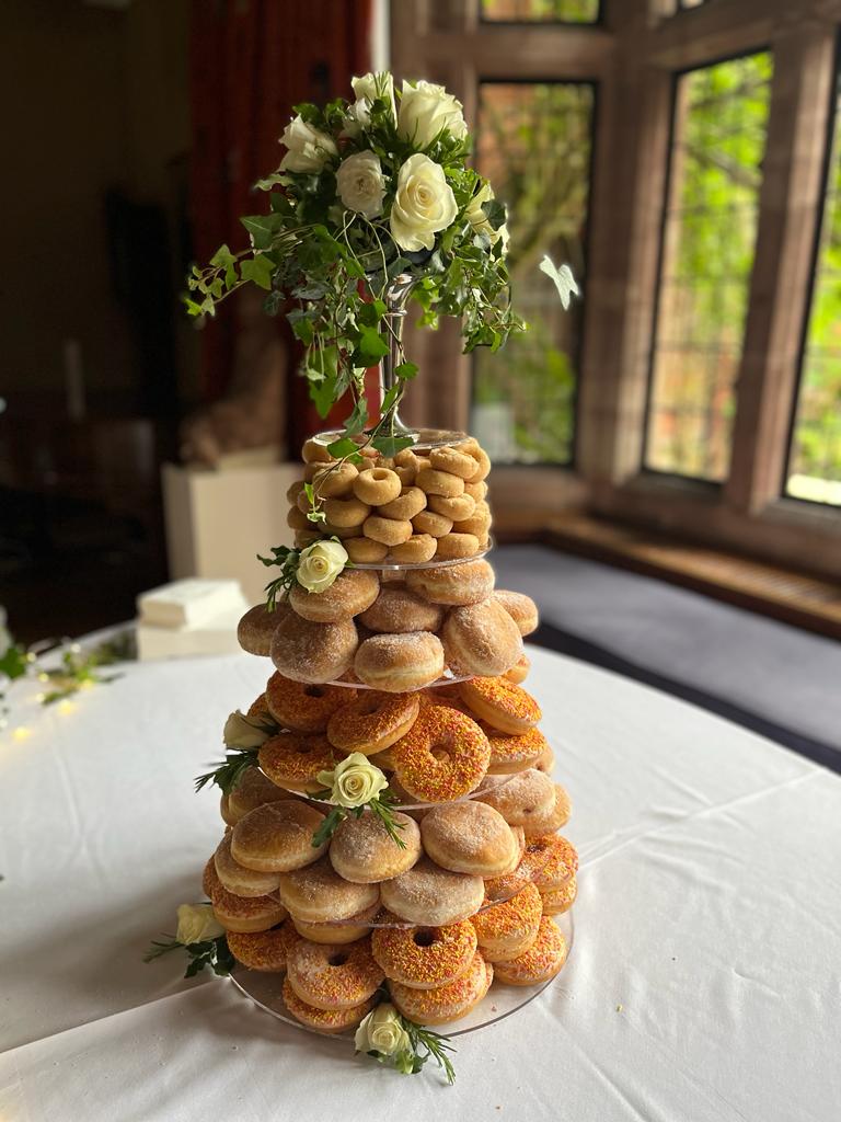 A wedding cake made from assorted donuts.