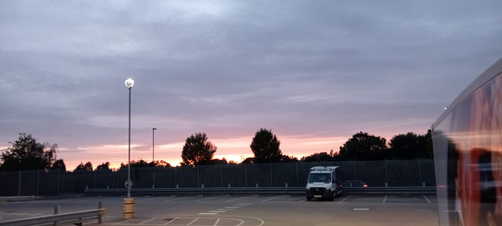 Pink and yellow sunset over a fence